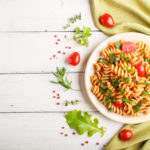 Fusilli pasta with tomato sauce, cherry tomatoes, lettuce and he